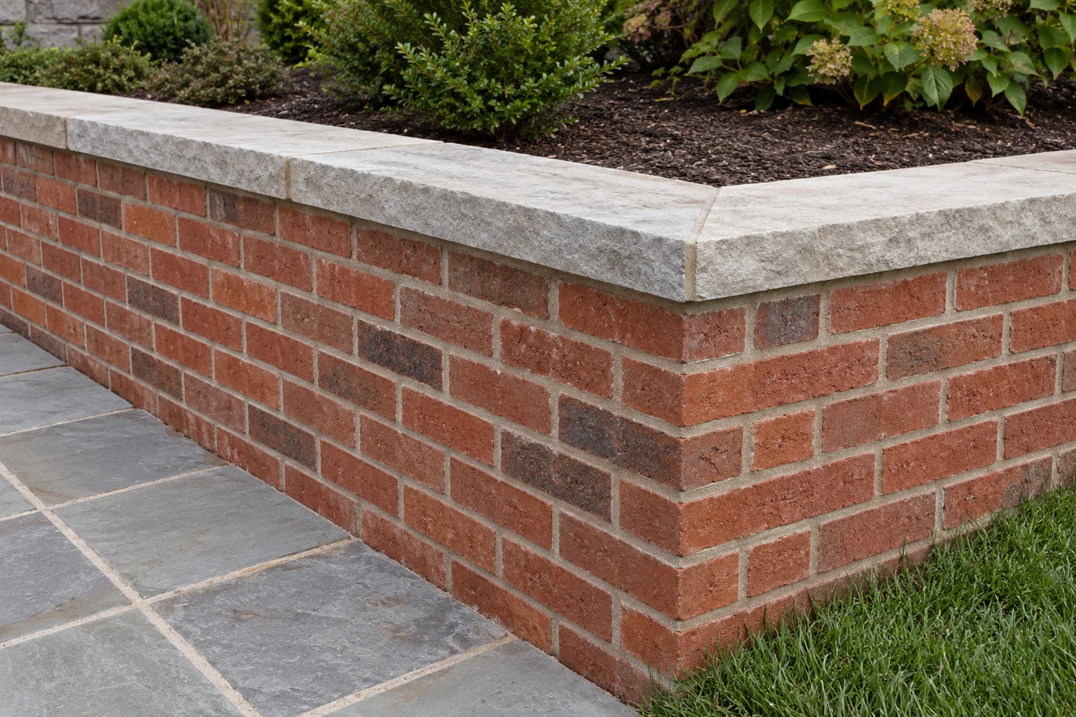 Brick retaining wall return with running bond masonry and fitted stone coping